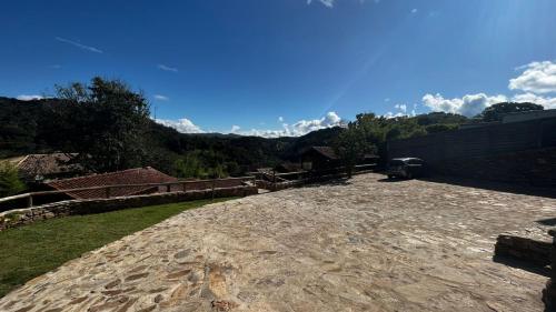 a stone patio with a view of a mountain at Chalés Ouro de Minas in Conceição da Ibitipoca