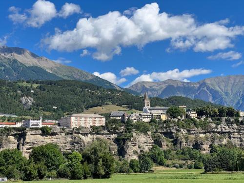 a town on top of a rocky mountain at Joli T2 - Vue sur Lac - 5 min du plan d'eau d'Embrun in Baratier