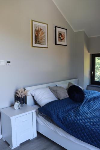 a bedroom with a bed with a blue comforter at Domek Lubkowo ,, Porto di Verde ’’Kaszuby, blisko morze, Dębki 8km in Lubkowo