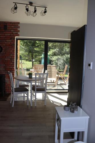 a dining room with a white table and chairs at Domek Lubkowo ,, Porto di Verde ’’Kaszuby, blisko morze, Dębki 8km in Lubkowo