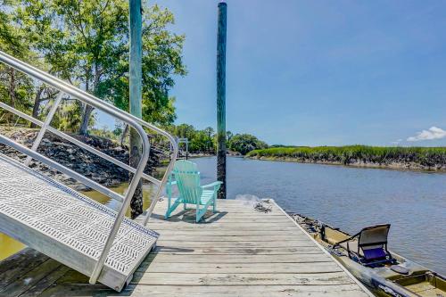 two chairs sitting on a dock next to the water at In Spite of Ourselves in Edisto Beach
