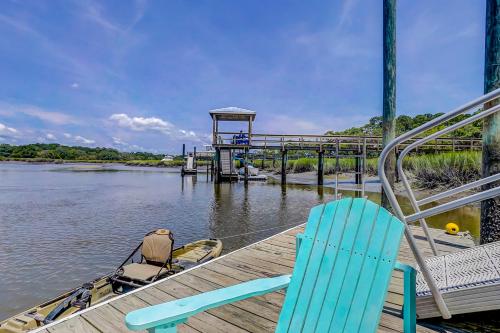 a deck with two chairs and a lifeguard tower on the water at In Spite of Ourselves in Edisto Beach