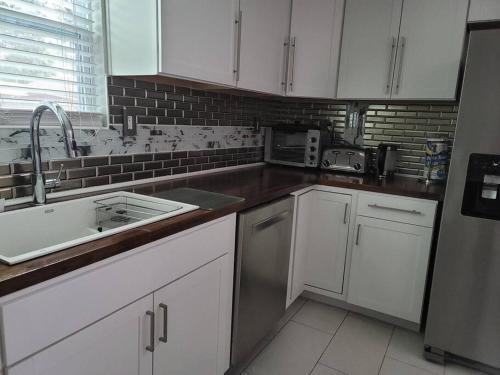 沃尔顿堡滩Dream house with capacity of 23 people的带白色橱柜和水槽的厨房