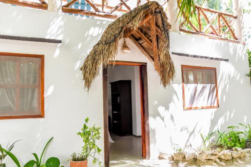 a hallway of a white building with a doorway at Zomay Beachfront Holbox in Holbox Island