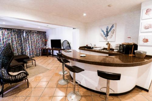a bar in a room with chairs and a counter at Hotel California Playa El Yaque in El Yaque