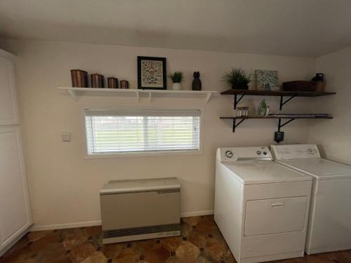 a laundry room with a washer and dryer and a window at Callie's Cottage in Hatch