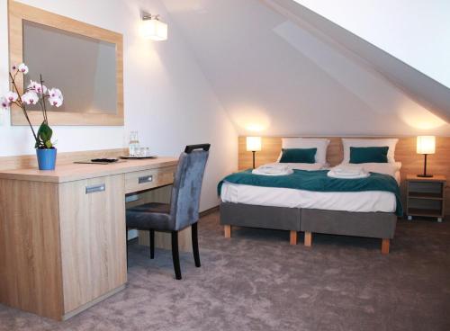 a bedroom with a bed and a desk with a desk at Perła Dunajca Zakliczyn in Zakliczyn