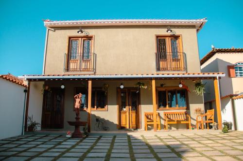 a house with a porch and chairs in front of it at Pouso Primavera in Tiradentes