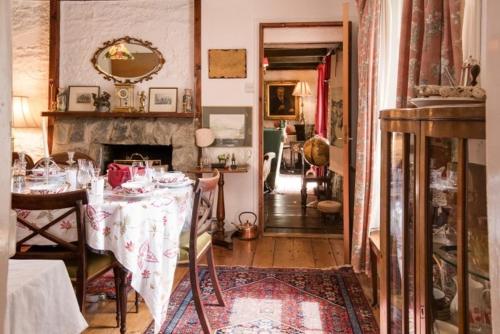 a dining room with a table and a fireplace at Strone House in Helensburgh