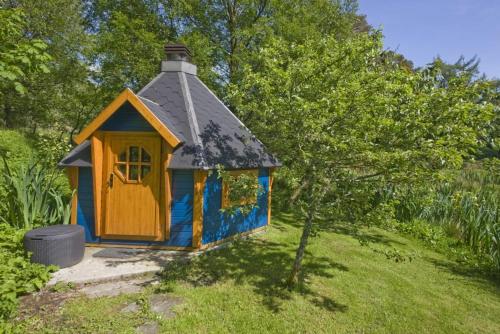 a small house with a roof in a yard at Strone House in Helensburgh