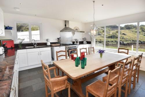 a kitchen with a large wooden table and chairs at Culkein Lodge in Drumbeg