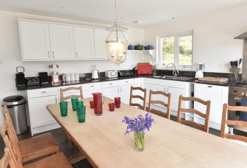 a kitchen with a wooden table with flowers on it at Culkein Lodge in Drumbeg