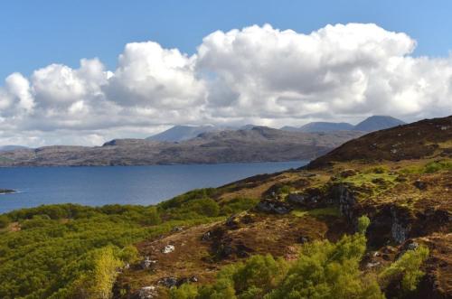 a view of a lake on a hill with mountains at Culkein Lodge in Drumbeg