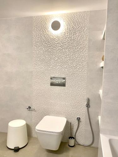 a white bathroom with a toilet and a sink at Gerani Deluxe Houses 2 in Astypalaia Town