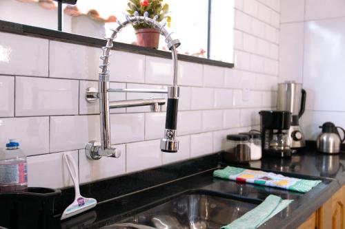 a kitchen sink with a faucet over it at Pouso Primavera in Tiradentes
