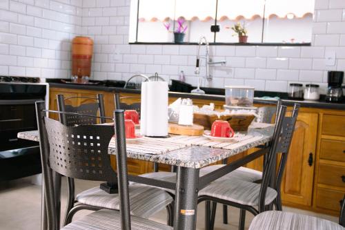 a table in a kitchen with a table and chairs at Pouso Primavera in Tiradentes