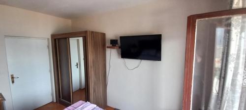 une pièce avec une télévision à écran plat sur un mur dans l'établissement Rooms Vlaovic, à Herceg-Novi