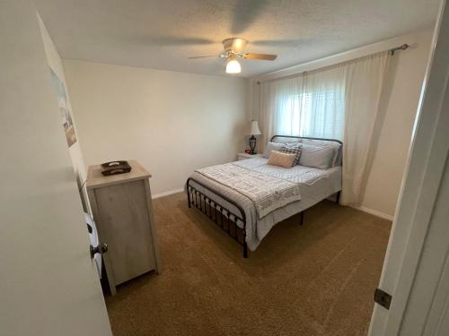 a bedroom with a bed and a ceiling fan at Callie's Cottage in Hatch