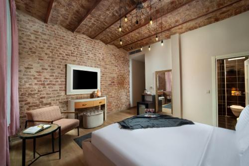 فندق ناين إسطنبول في إسطنبول: غرفة نوم بسرير وجدار من الطوب