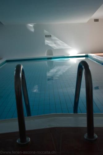 a swimming pool with a blue tile floor at Casa Roccalta in Ascona
