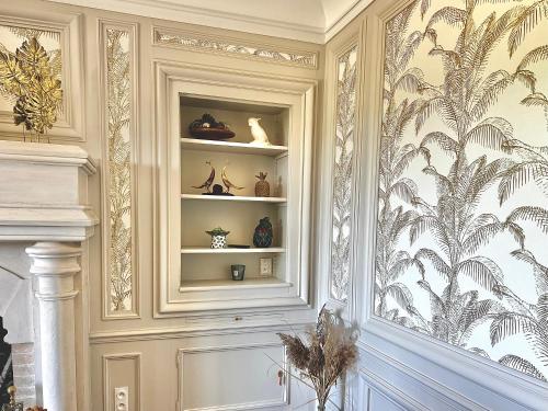 a room with a wall with a shelf with vases at Demeure de la Garenne in Montmirail
