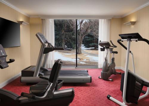 a gym with three exercise bikes and a window at Little America Hotel - Wyoming in Little America