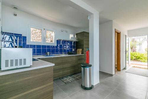 a kitchen with blue tiles and a red fire hydrant at Rosa Challet in Santa Úrsula