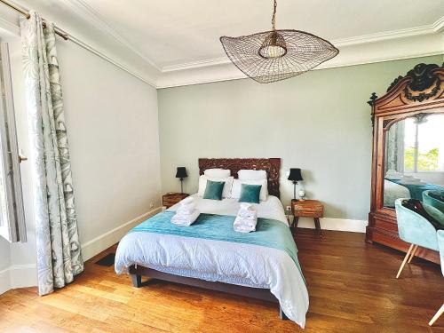 a bedroom with a bed and a chandelier at Demeure de la Garenne in Montmirail
