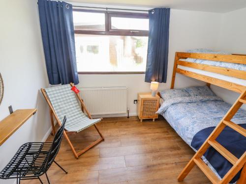 - une chambre avec des lits superposés et une chaise dans l'établissement Rollin' Dunes, à Grimsby
