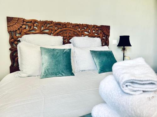 a white bed with white pillows and a wooden headboard at Demeure de la Garenne in Montmirail