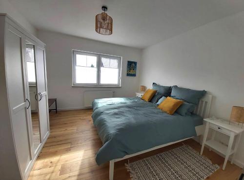 a bedroom with a bed with blue sheets and a window at Ferienwohnung mit Terrasse am Rosengarten in Alzenau