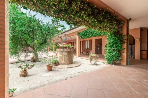 een toegang tot een gebouw met een patio met planten bij Italian Experience-Villa Rosso Corbezzolo in Carassai