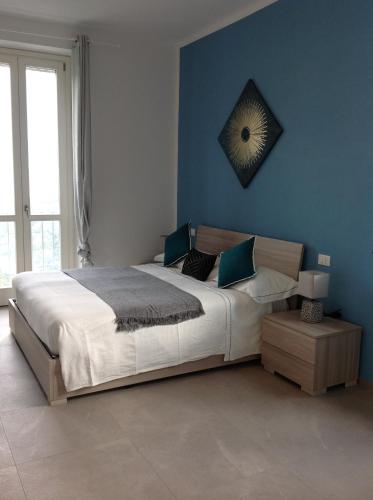a bedroom with a large bed with blue walls at Affittacamereirosmarini in Vernazza