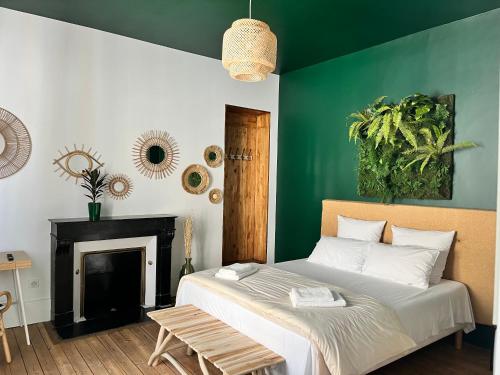 um quarto com uma cama e uma parede verde em Le Gîte de Jean Thevenin, avec parking gratuit em Épernay