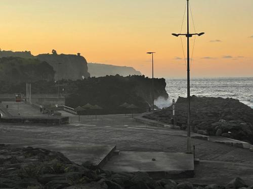a view of a beach with the ocean and a street light at Azores Casa da Mata in São Vicente Ferreira