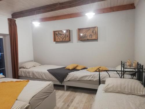 a bedroom with two beds and two mirrors on the wall at Pri kovačih, Istra autentica in Movraž