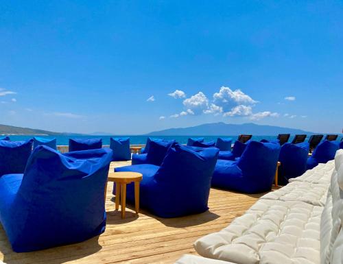 eine Reihe blauer Stühle auf einem Deck in der Unterkunft Hotel Nertili in Sarandë