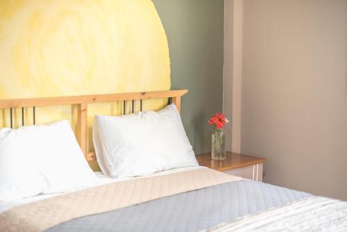 a bed with two pillows and a vase with a flower at Castle's Nest 1 in Kástro Tornéze