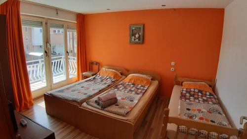 twee bedden in een kamer met een oranje muur bij Tija Apartments in Ohrid