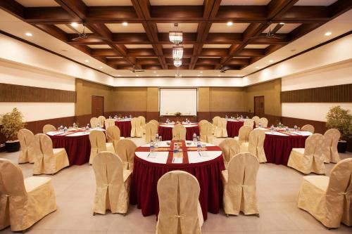 a conference room with tables and chairs and a screen at Sterling Munnar in Munnar