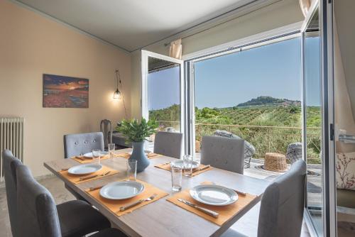 a dining room with a table and a large window at Castle's Nest 1 in Kástro Tornéze