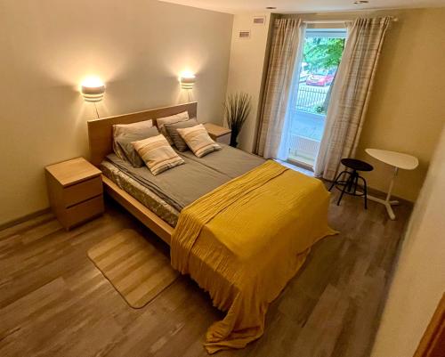 a bedroom with a bed with a yellow blanket and a window at Cozy vibes like home it is quiet apartment with three bedrooms in Rīga
