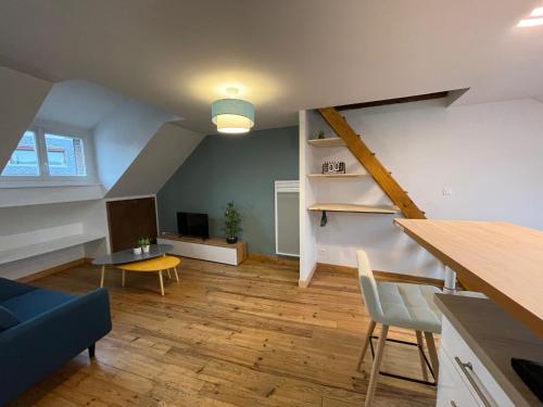 a living room with a staircase and a table and chairs at Appartement cosy au coeur d'Espalion in Espalion