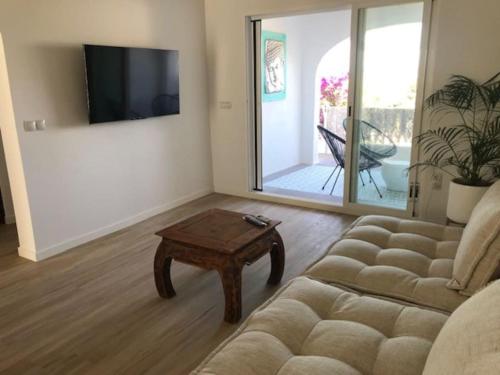 Una sala de estar con un sofá y una mesa de café. en MORAIRA, PRECIOSO ADOSADO al LADO DEL MAR, en Moraira