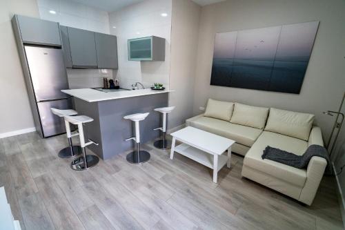 sala de estar con sofá y cocina en Apartamento Cabildo Spa 2 en Sanlúcar de Barrameda
