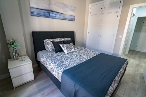 1 dormitorio con 1 cama y armario blanco en Apartamento Cabildo Spa 2 en Sanlúcar de Barrameda