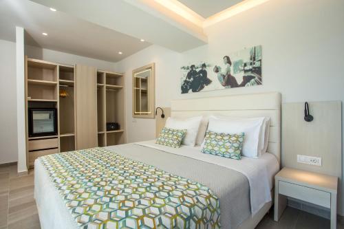a bedroom with a large bed and a tv at Hollywood Inn Faliraki - Adults Only in Faliraki