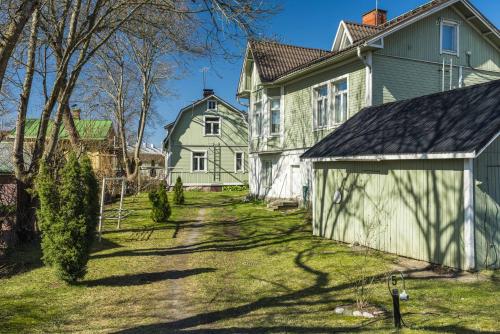 uma casa antiga com garagem num quintal em Newly renovated apartment in a woodenhouse from 1910 in Martti! em Turku