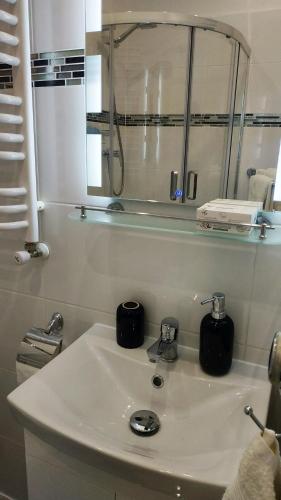 a white bathroom with a sink and a mirror at Apartamenty gościnne na szlaku in Złoty Stok