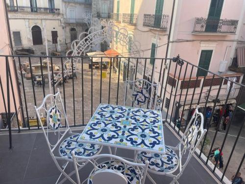 a blue and white table and chairs on a balcony at Palazzo Sarti Suites in Rodi Garganico